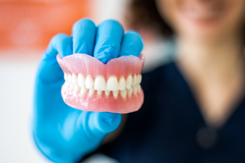 Dentist Holding Full Dentures